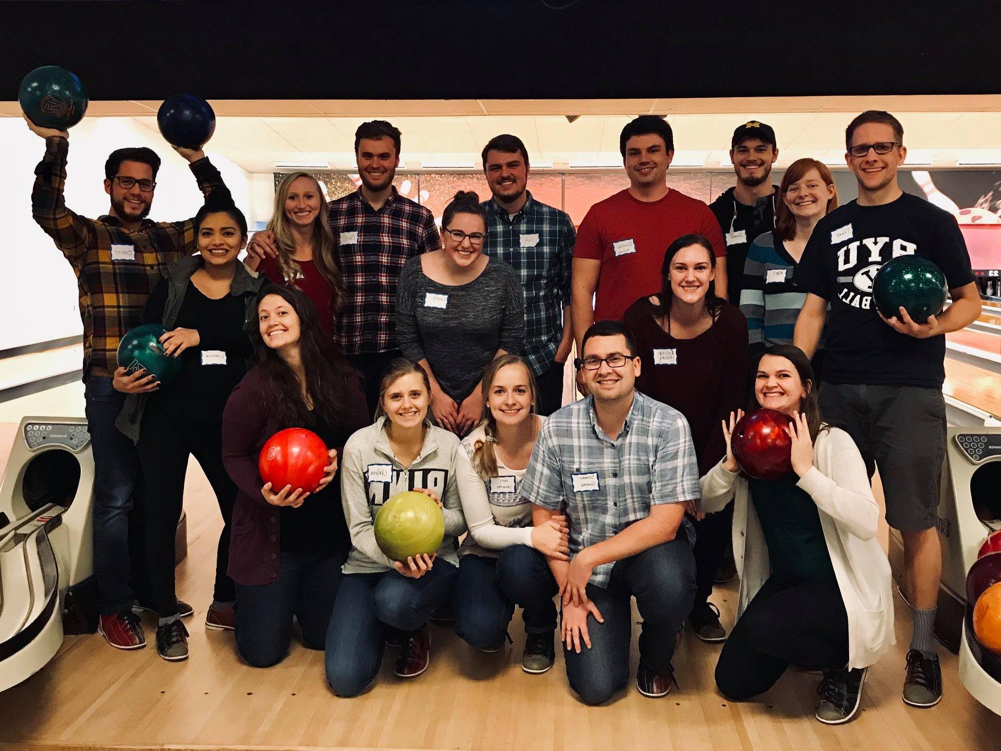 A group of OUWB students and their significant others pose with their bowling balls at the bowling alley.